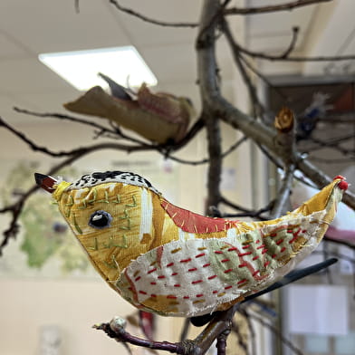 Les oiseaux de L'Aiguillée Studio dans la vitrine de l'office de tourisme